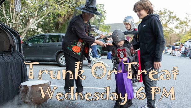 Woman dressed as witch giving out candy to kids